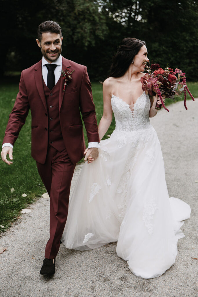 glückliches Brautpaar Hand in Hand mit Brautstrauß