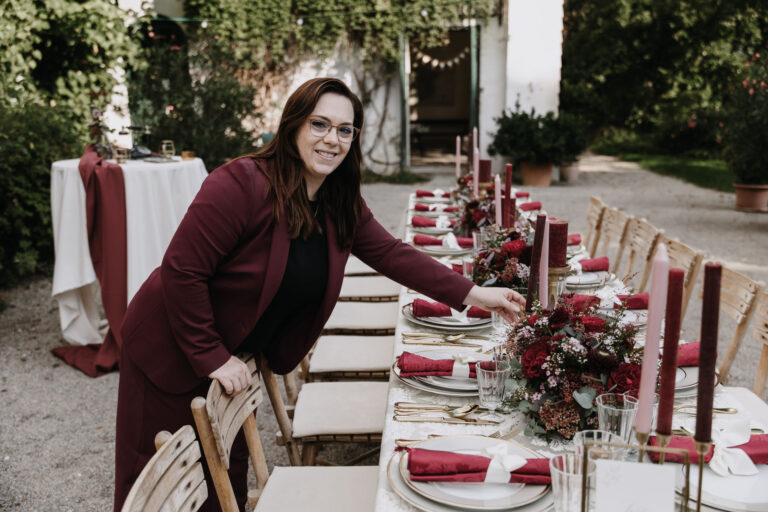 Melanie Hutterer beim dekorieren einer Hochzeitstafel in den Farben burgunder, zartrosa, champagner und gold