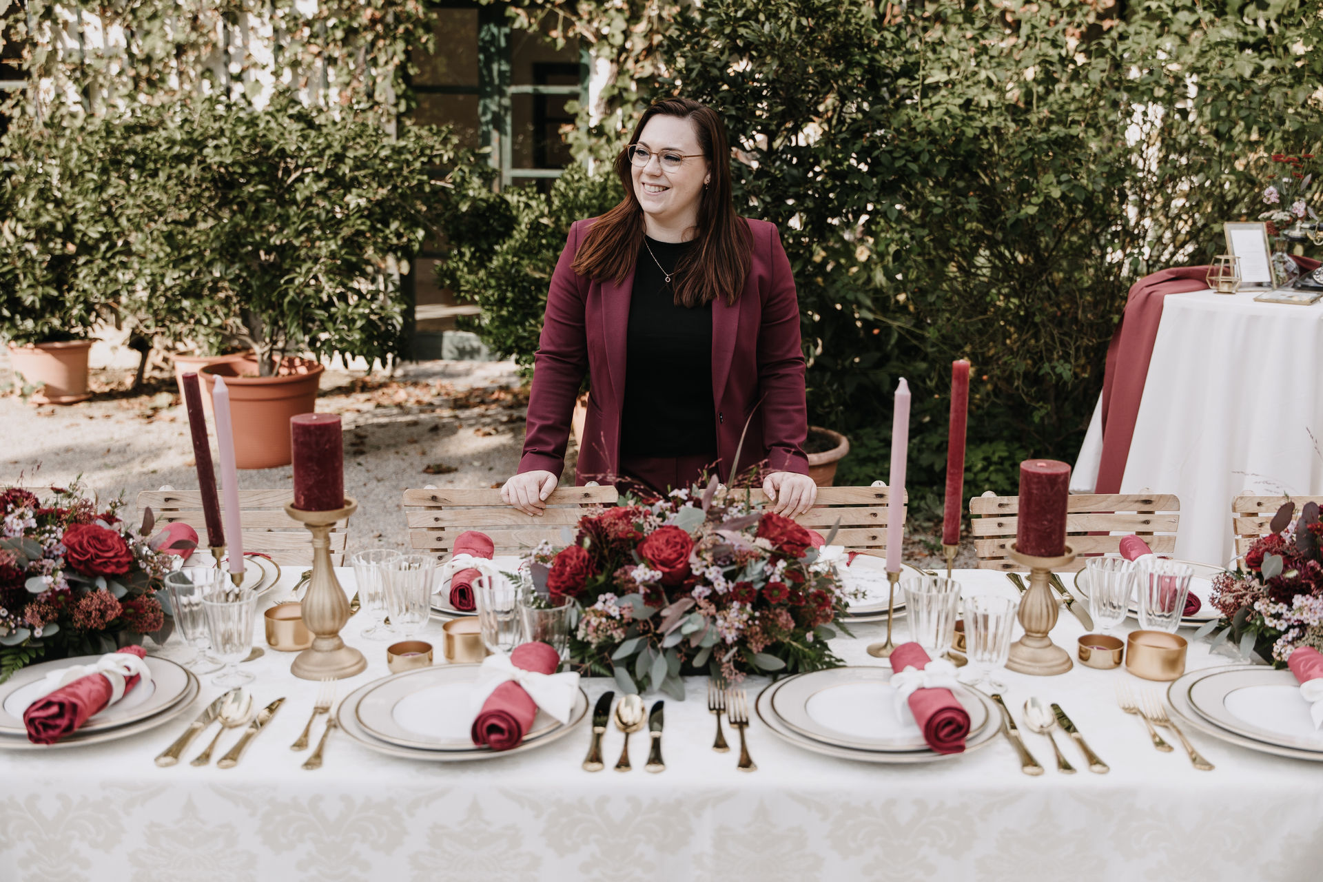 Melanie Hutterer beim dekorieren einer Hochzeitstafel in den Farben burgunder, zartrosa, champagner und gold