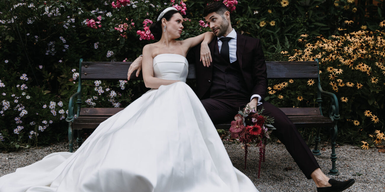 Brautpaar sitzt auf einer Parkbank